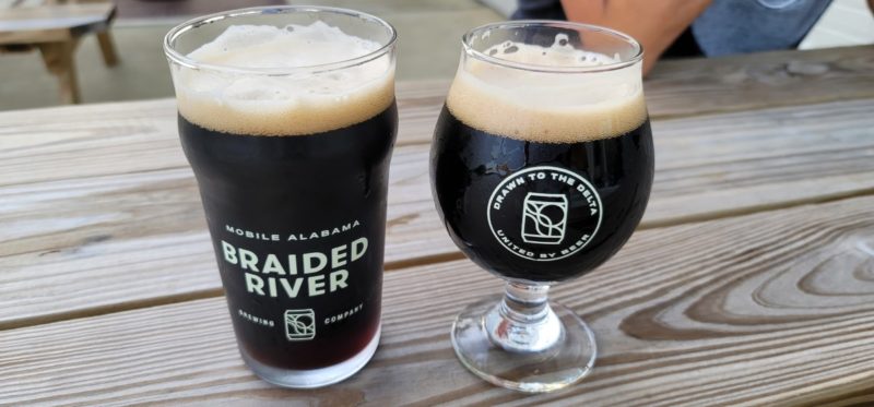 Two dark beers on a picnic table at Braided River Brewing Company.