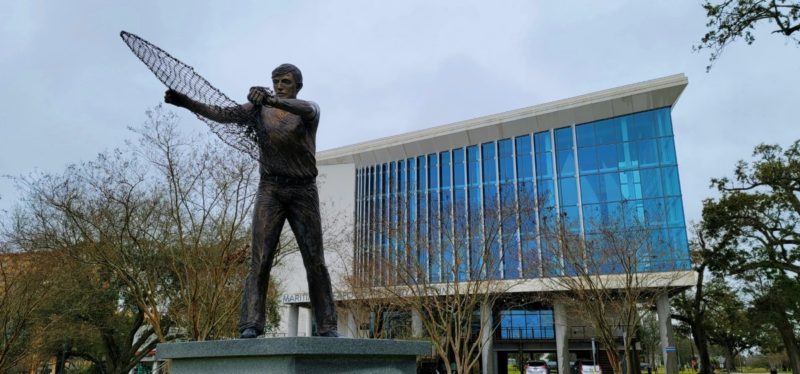 A statue of a fisherman in front of the Maritime & Seafood Industry Museum.