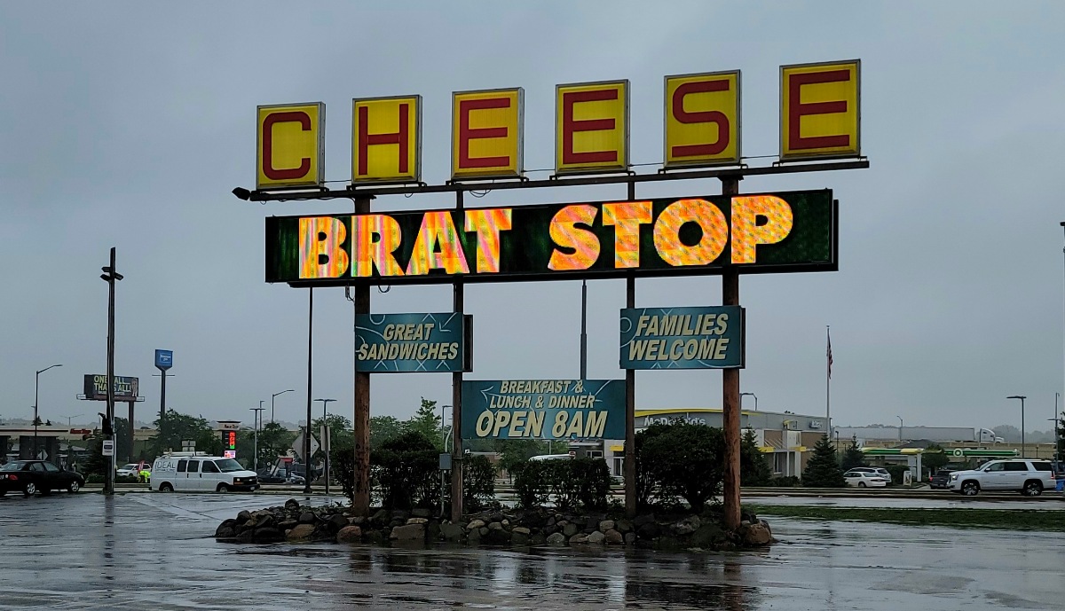 The Brat Stop sign that reads CHEESE BRAT STOP in big bold letters.