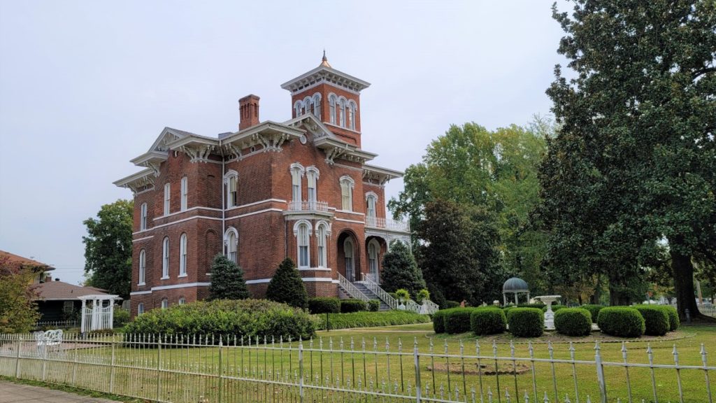 The exterior of the Magnolia Manor, a red brick Victorian historic mansion in Cairo, Illinois.