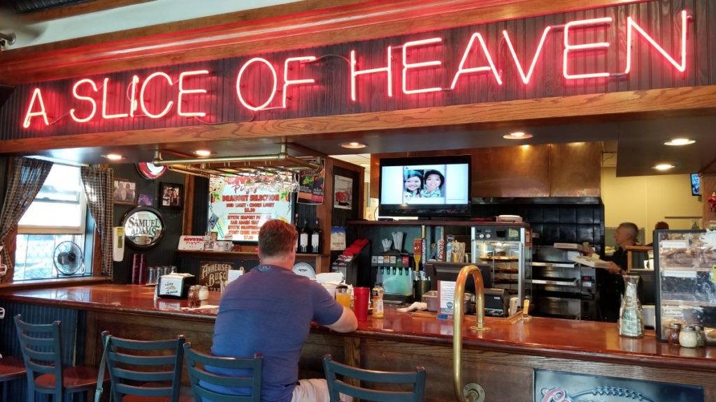 Inside bar at Mystic Pizza that has a neon sign saying, "A slice of Heaven"