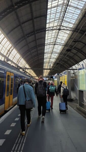 People walking with luggage in a train station.